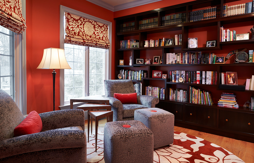Design ideas for a mid-sized traditional home office in DC Metro with a library, red walls, medium hardwood floors and brown floor.