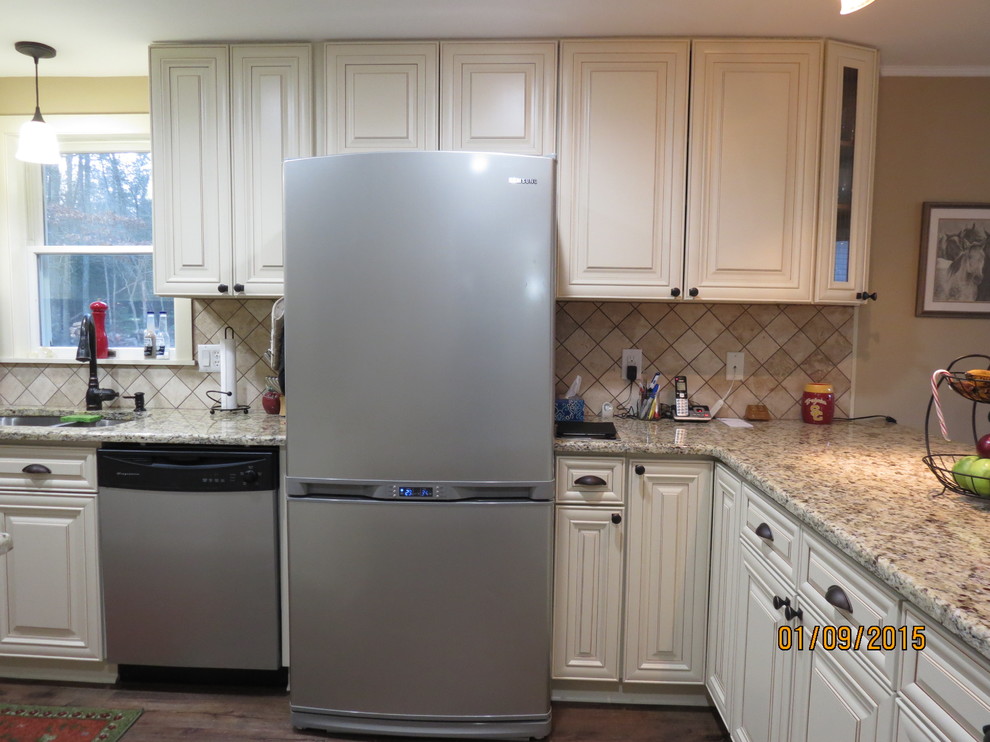 Inspiration for a mid-sized u-shaped eat-in kitchen remodel in DC Metro with a double-bowl sink, raised-panel cabinets, white cabinets, granite countertops, beige backsplash, porcelain backsplash and stainless steel appliances