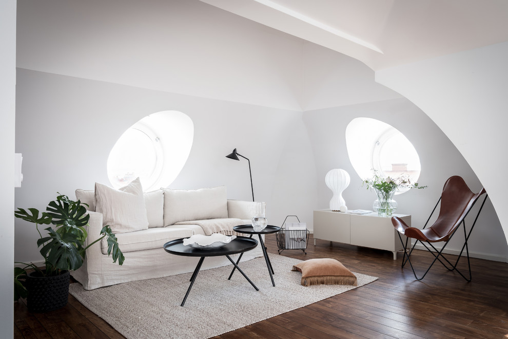 This is an example of a scandinavian open concept living room in Gothenburg with white walls, dark hardwood floors and no fireplace.