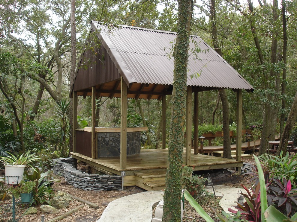 Design ideas for a mid-sized tropical backyard patio in Tampa with a gazebo/cabana.