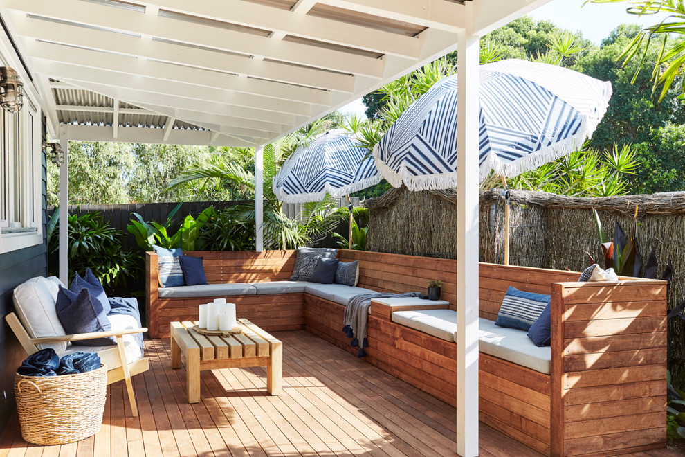 Design ideas for a large tropical side yard deck in Sydney with a roof extension.