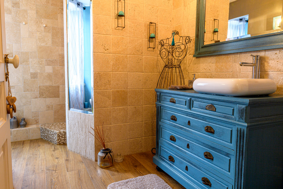 This is an example of a small traditional bathroom in Nancy with a two-piece toilet, beige tiles, travertine tiles, beige walls, laminate floors, brown floors, blue worktops and a single sink.