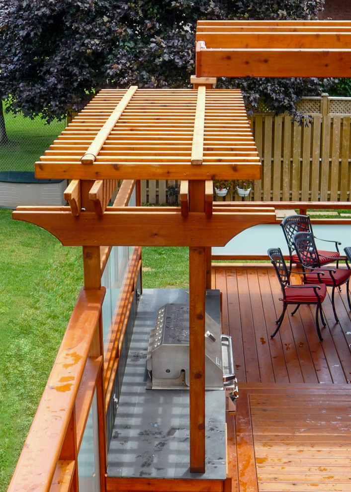 Mid-sized traditional backyard deck in Toronto with an outdoor kitchen and a pergola.
