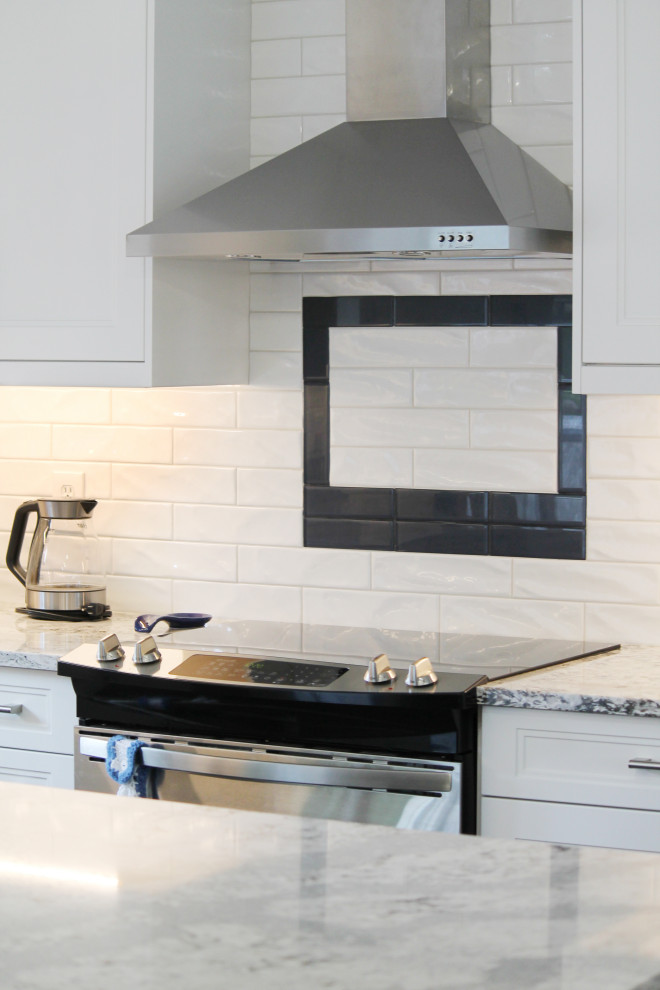 Eat-in kitchen - large transitional u-shaped eat-in kitchen idea with shaker cabinets, white cabinets, quartz countertops, white backsplash, subway tile backsplash, stainless steel appliances, an island and gray countertops