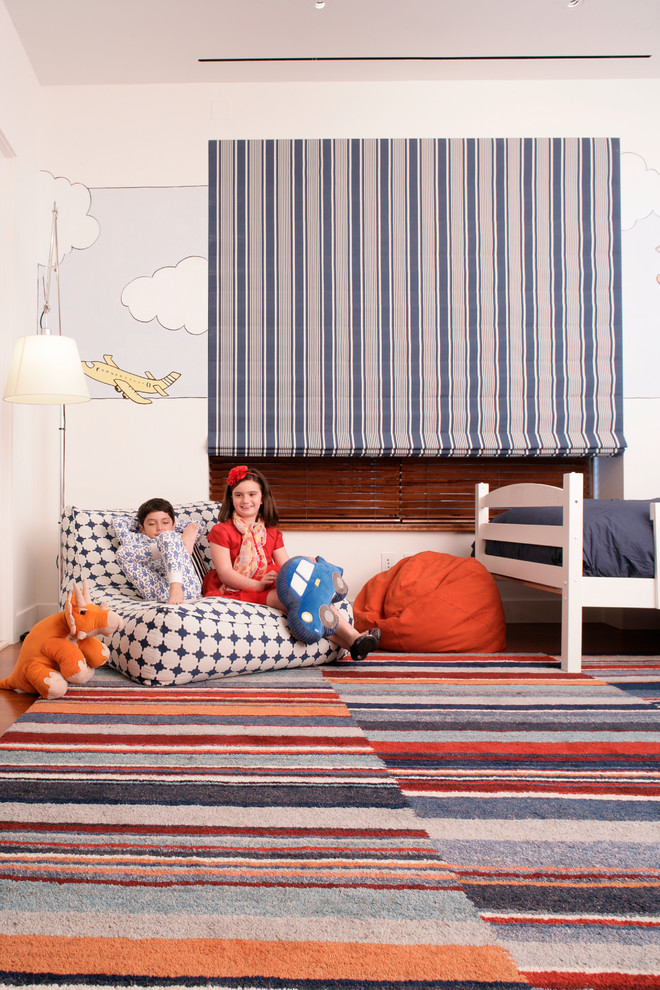This is an example of a mid-sized contemporary gender-neutral kids' bedroom in New York with multi-coloured walls and medium hardwood floors.