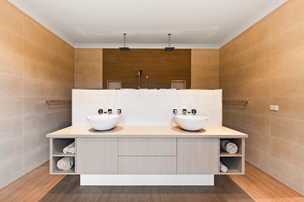 This is an example of a contemporary bathroom in Sydney with a freestanding tub, an open shower, beige tile, porcelain tile, beige walls and porcelain floors.