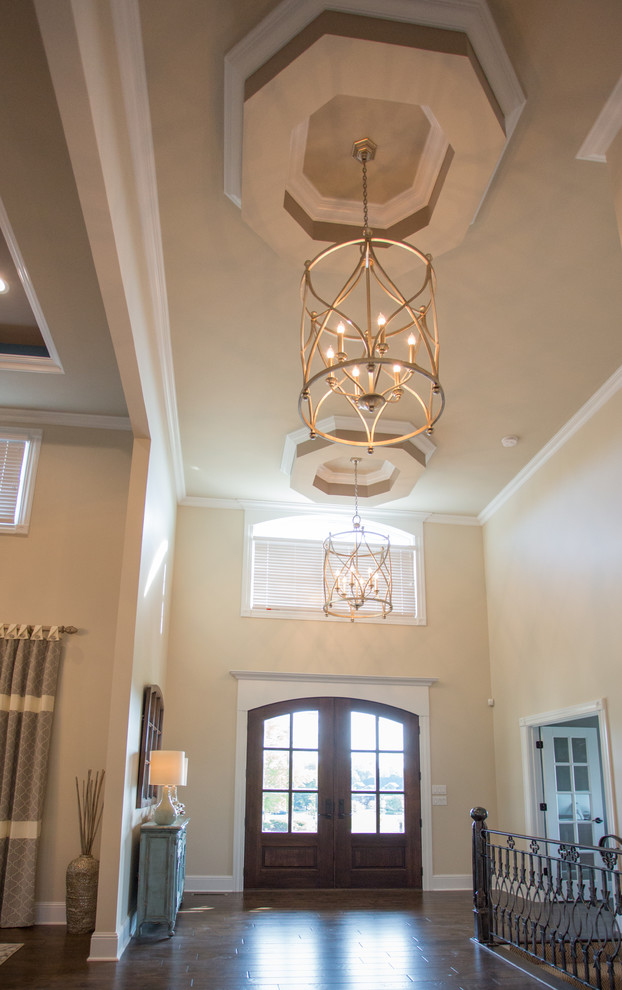 Foyer - mid-sized brown floor foyer idea with beige walls and a dark wood front door