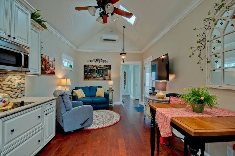 Mid-sized traditional open concept living room in Other with medium hardwood floors, a wall-mounted tv and beige walls.