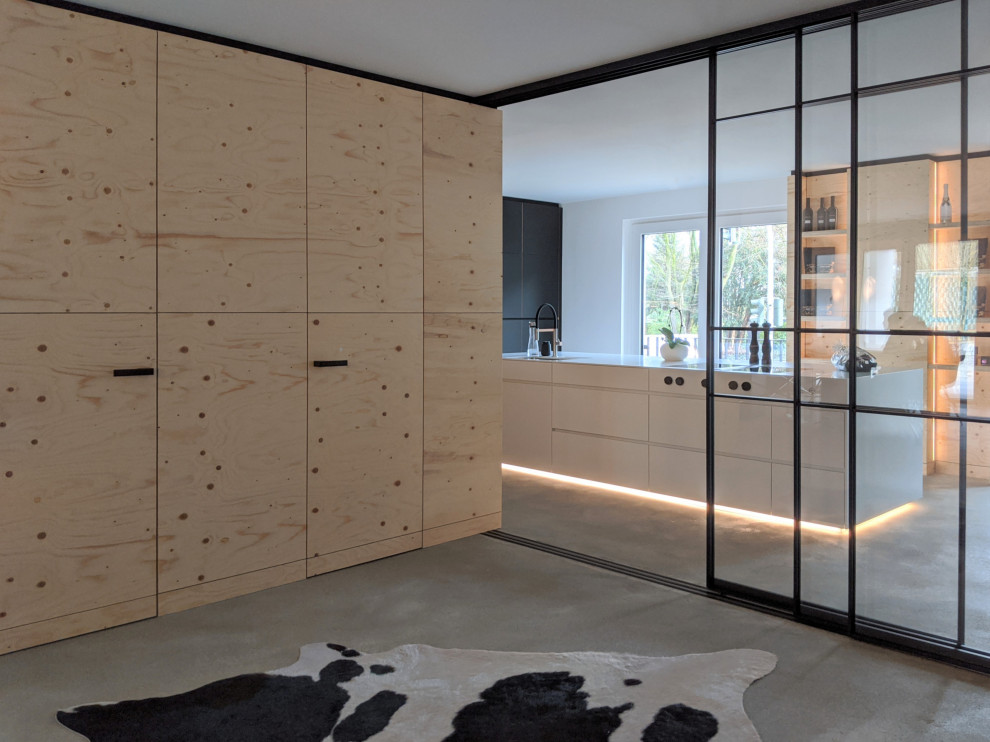 This is an example of a large industrial kitchen in Essen with flat-panel cabinets, black cabinets and with island.