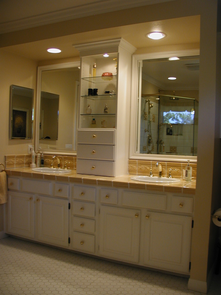 This is an example of a mid-sized traditional master bathroom in Los Angeles with a drop-in sink, raised-panel cabinets, white cabinets, tile benchtops, ceramic tile and porcelain floors.