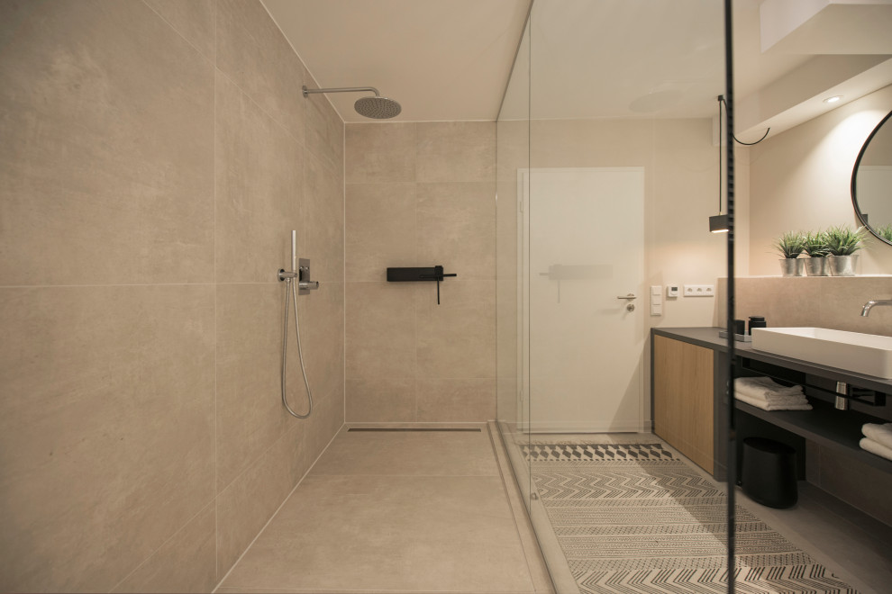Photo of a large modern bathroom in Munich with flat-panel cabinets, black cabinets, an open shower, a two-piece toilet, gray tile, ceramic tile, beige walls, ceramic floors, a vessel sink, wood benchtops, grey floor, an open shower, black benchtops, a single vanity and a built-in vanity.