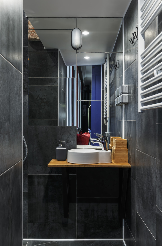 This is an example of a small contemporary bathroom in Saint Petersburg with black tile, porcelain tile, porcelain floors, a vessel sink, wood benchtops and black floor.