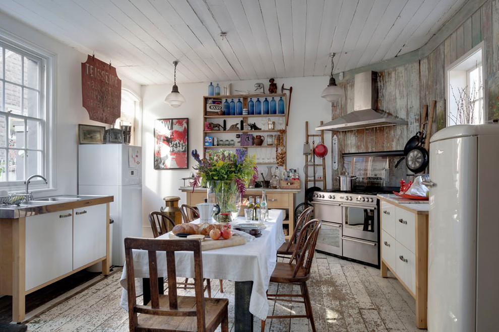 Foto de cocina romántica con armarios con paneles lisos, puertas de armario blancas, electrodomésticos de acero inoxidable y suelo de madera pintada