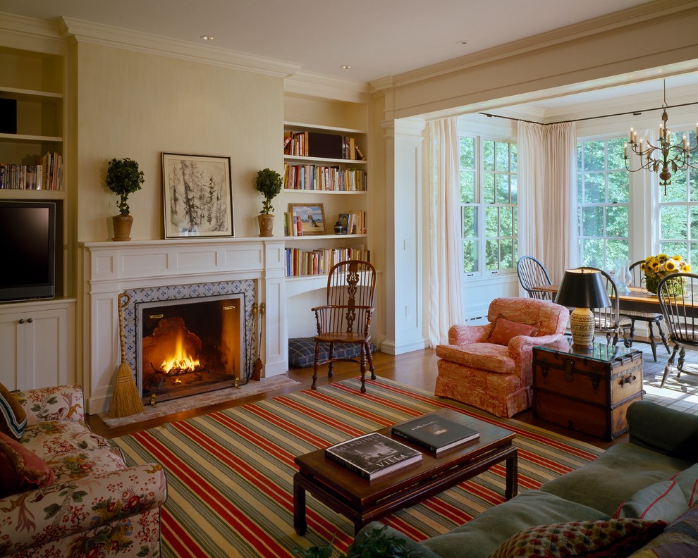 Design ideas for a mid-sized traditional open concept family room in Boston with white walls, medium hardwood floors, a standard fireplace, a tile fireplace surround, a built-in media wall and brown floor.
