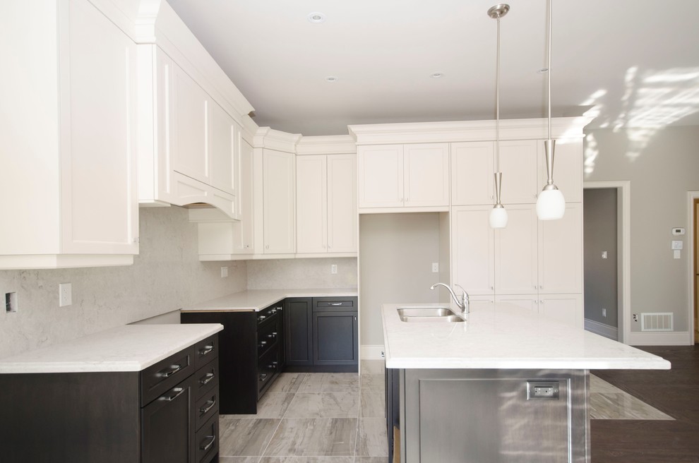 Inspiration for a mid-sized transitional l-shaped porcelain tile kitchen remodel in Toronto with a double-bowl sink, shaker cabinets, white cabinets, white backsplash, marble backsplash, stainless steel appliances and an island