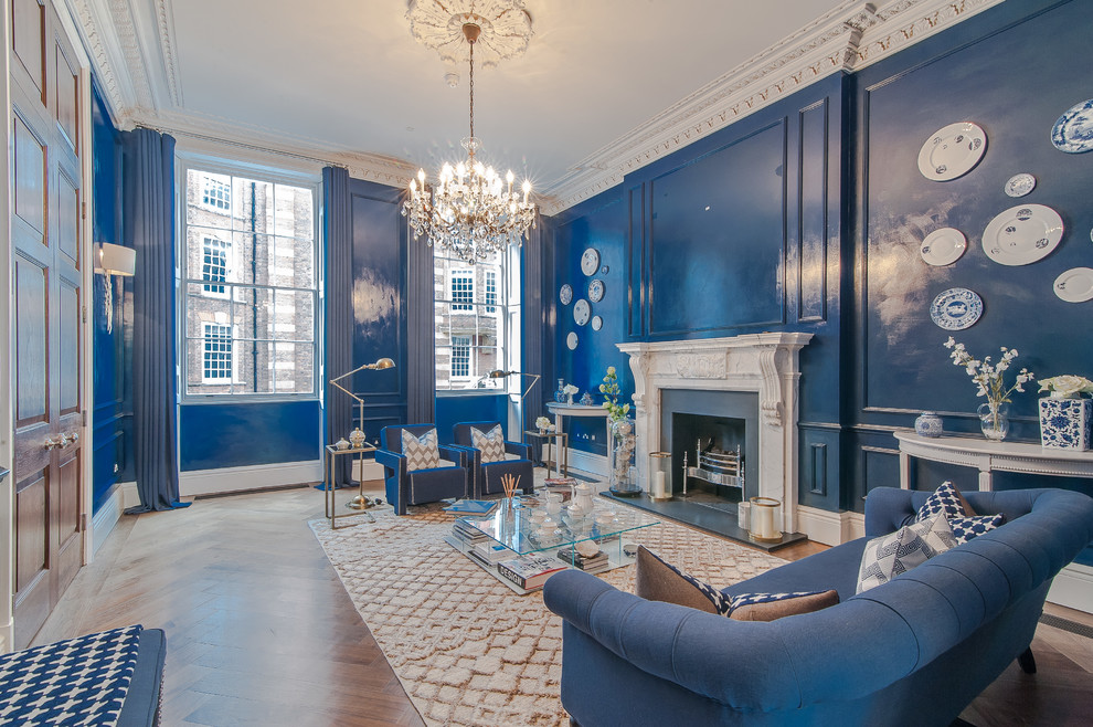 Inspiration for an expansive traditional formal open concept living room in London with blue walls, dark hardwood floors, a standard fireplace, a stone fireplace surround and no tv.