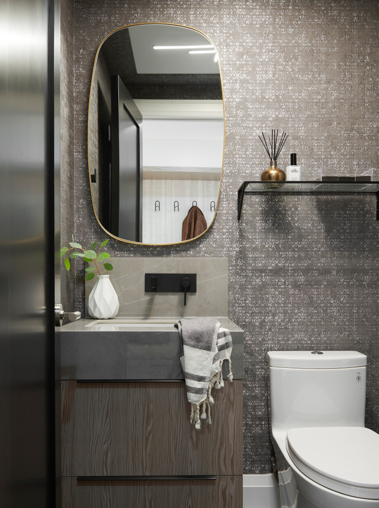 Inspiration for a small contemporary powder room in Toronto with flat-panel cabinets, grey cabinets, a one-piece toilet, grey walls, brick floors, an undermount sink, engineered quartz benchtops, black floor, grey benchtops, a built-in vanity and wallpaper.