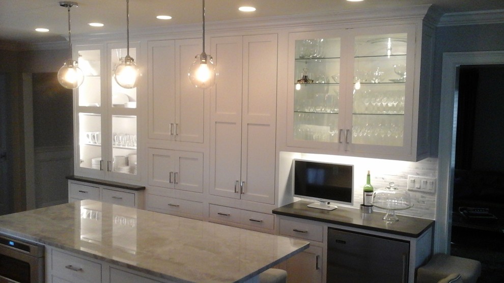 Mid-sized transitional l-shaped light wood floor eat-in kitchen photo in Newark with a double-bowl sink, shaker cabinets, white cabinets, solid surface countertops, multicolored backsplash, stone tile backsplash, stainless steel appliances and an island