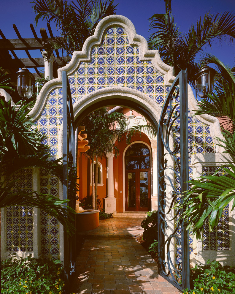Photo of a mediterranean entryway in Miami with a double front door and pink walls.