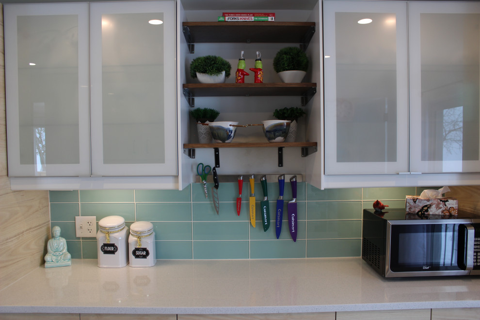 This is an example of a large country galley eat-in kitchen in Other with an undermount sink, flat-panel cabinets, light wood cabinets, quartz benchtops, green splashback, ceramic splashback, stainless steel appliances, vinyl floors, with island, grey floor, white benchtop and recessed.