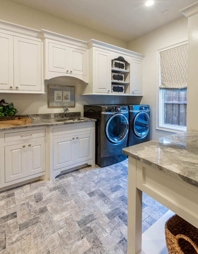 Inspiration for a large rustic ceramic tile utility room remodel in Austin with an undermount sink, shaker cabinets, white cabinets, granite countertops, white walls and a side-by-side washer/dryer