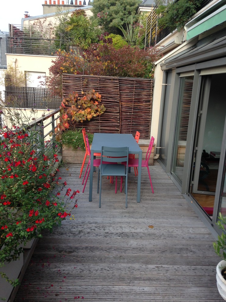 Photo of a large contemporary side yard deck in Paris with a container garden.