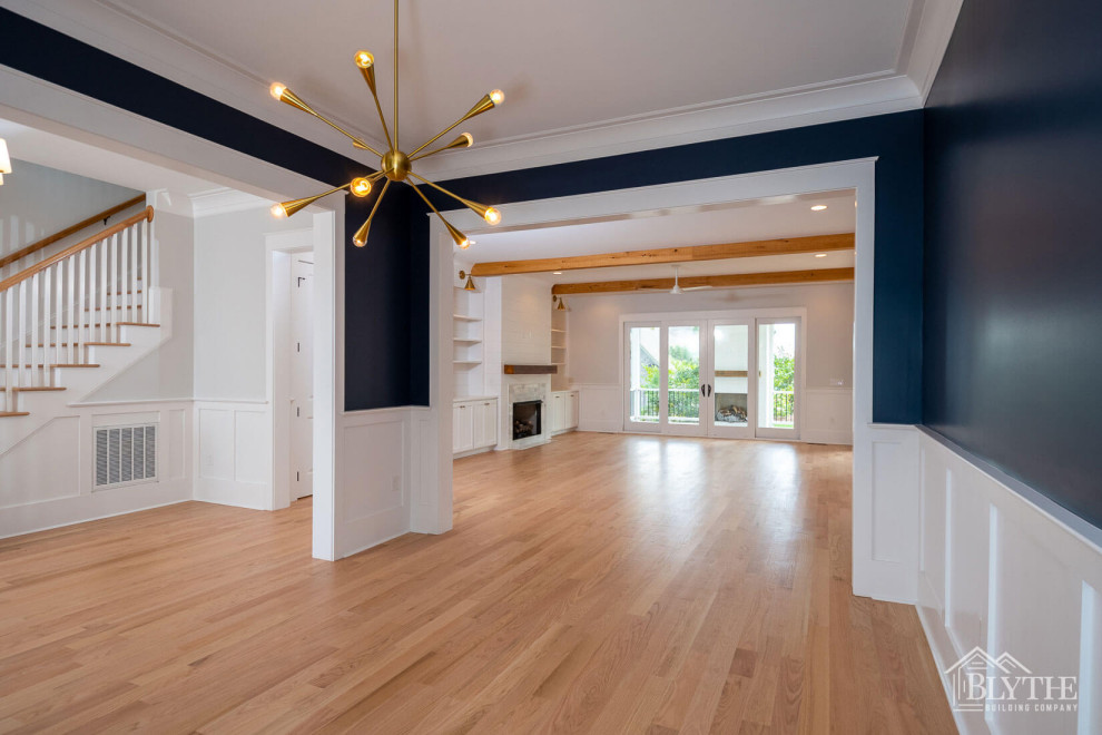 Photo of a mid-sized arts and crafts separate dining room in Other with blue walls, light hardwood floors, a standard fireplace, a tile fireplace surround, brown floor and decorative wall panelling.