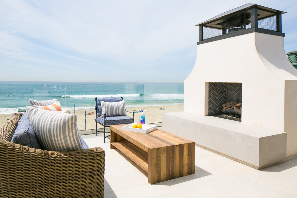 Photo of a large beach style deck in Orange County with a fire feature and no cover.
