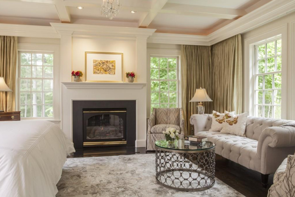 Design ideas for a large traditional master bedroom in Boston with beige walls, carpet, a standard fireplace, a wood fireplace surround and multi-coloured floor.