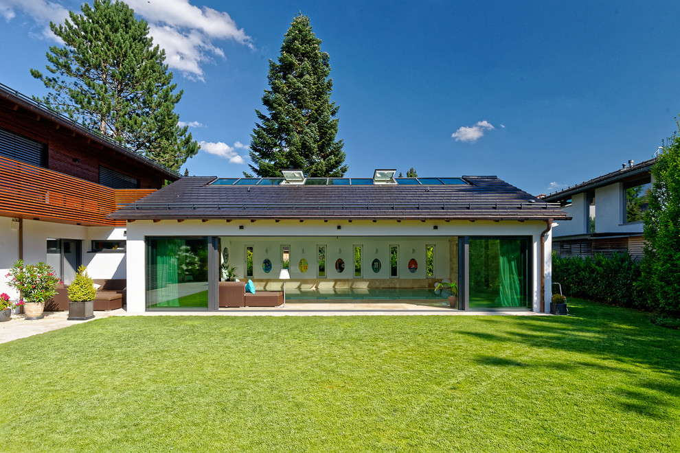 Mittelgroßer Moderner Pool in rechteckiger Form mit Natursteinplatten in München