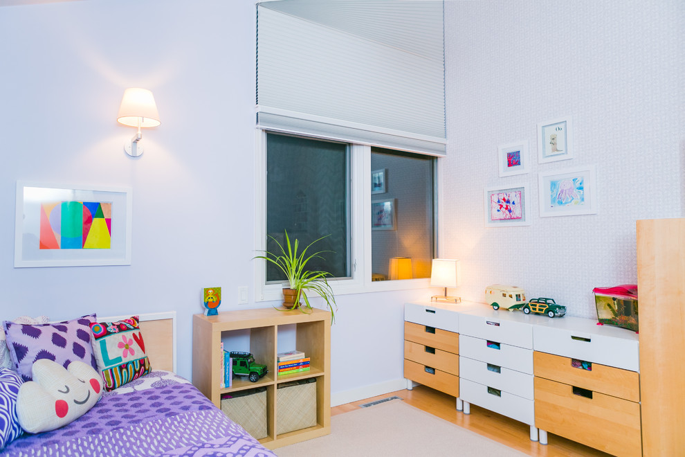 Contemporary gender-neutral kids' bedroom in Boston with medium hardwood floors and white walls for kids 4-10 years old.