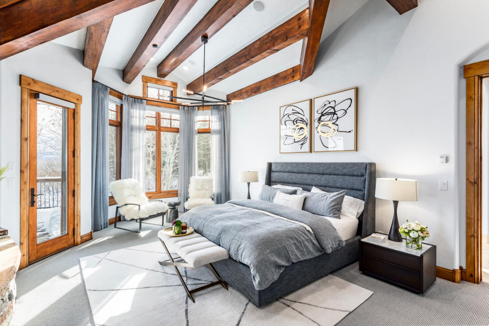 Design ideas for a large contemporary master bedroom in Salt Lake City with white walls, carpet, a standard fireplace, a stone fireplace surround, grey floors and exposed beams.