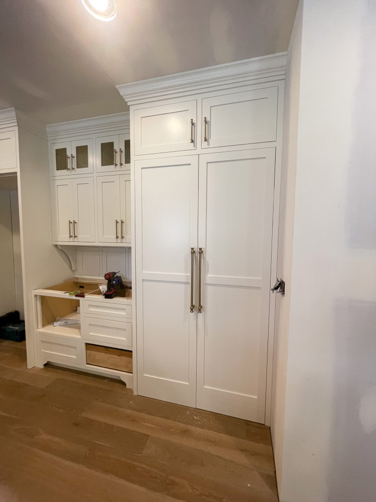 Imagen de cocina comedor minimalista grande con armarios estilo shaker, puertas de armario blancas, salpicadero blanco, suelo de madera en tonos medios y una isla