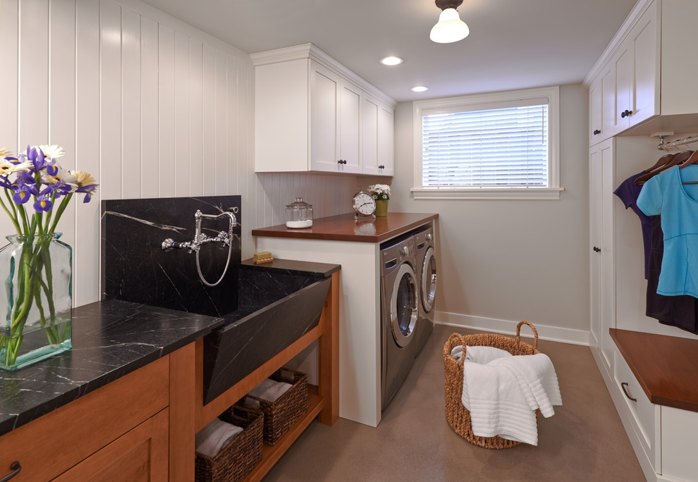 Design ideas for a traditional galley utility room in Seattle with a farmhouse sink, shaker cabinets, white cabinets, soapstone benchtops, white walls, concrete floors and a side-by-side washer and dryer.