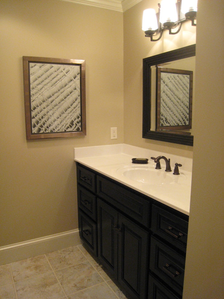 Bathroom - mid-sized transitional ceramic tile bathroom idea with raised-panel cabinets, black cabinets, brown walls, an integrated sink and solid surface countertops