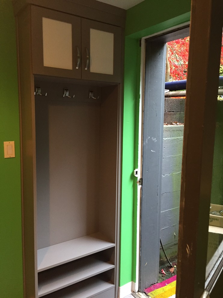 Inspiration for a mid-sized transitional medium tone wood floor mudroom remodel with green walls