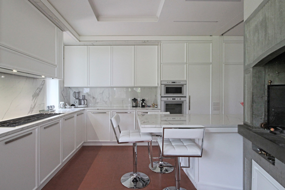This is an example of an expansive traditional eat-in kitchen in Milan with recessed-panel cabinets, marble benchtops, white appliances, ceramic floors, with island, red floor and white benchtop.