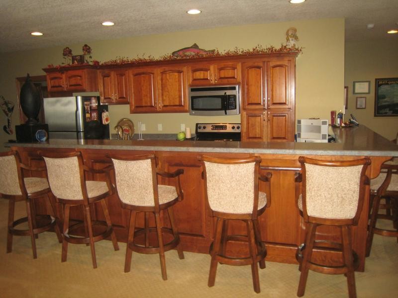 Eat-in kitchen - mid-sized traditional l-shaped carpeted and beige floor eat-in kitchen idea with an undermount sink, raised-panel cabinets, dark wood cabinets, granite countertops, stainless steel appliances and a peninsula