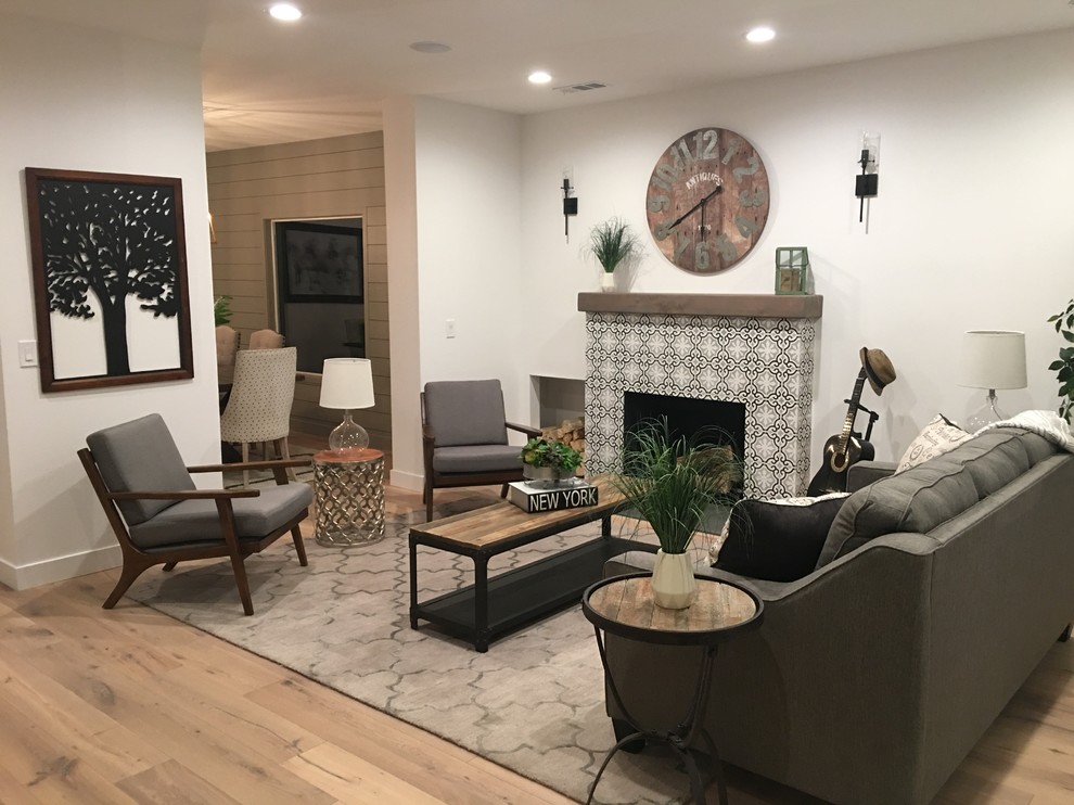 Inspiration for a large country formal open concept living room in Los Angeles with white walls, medium hardwood floors, a standard fireplace, a tile fireplace surround, brown floor and no tv.
