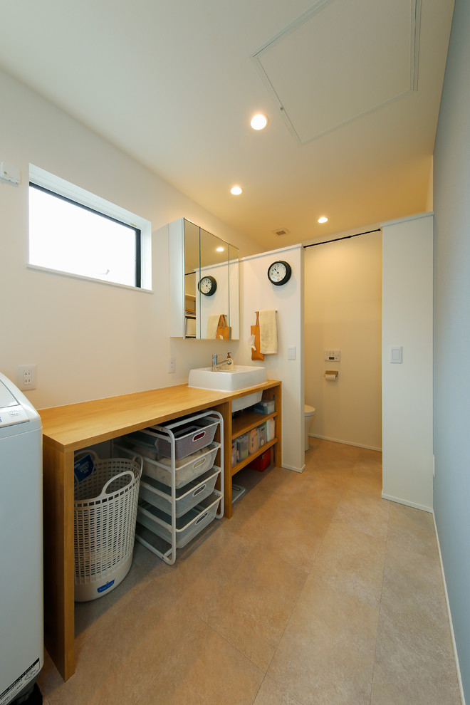Mid-sized scandinavian single-wall utility room in Tokyo with a drop-in sink, open cabinets, brown cabinets, wood benchtops, white walls, ceramic floors, an integrated washer and dryer, beige floor and brown benchtop.