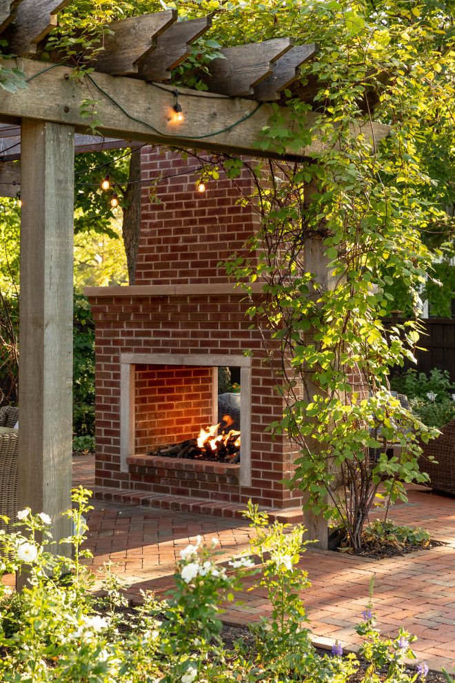 Esempio di un piccolo patio o portico stile americano dietro casa con un caminetto, pavimentazioni in mattoni e una pergola