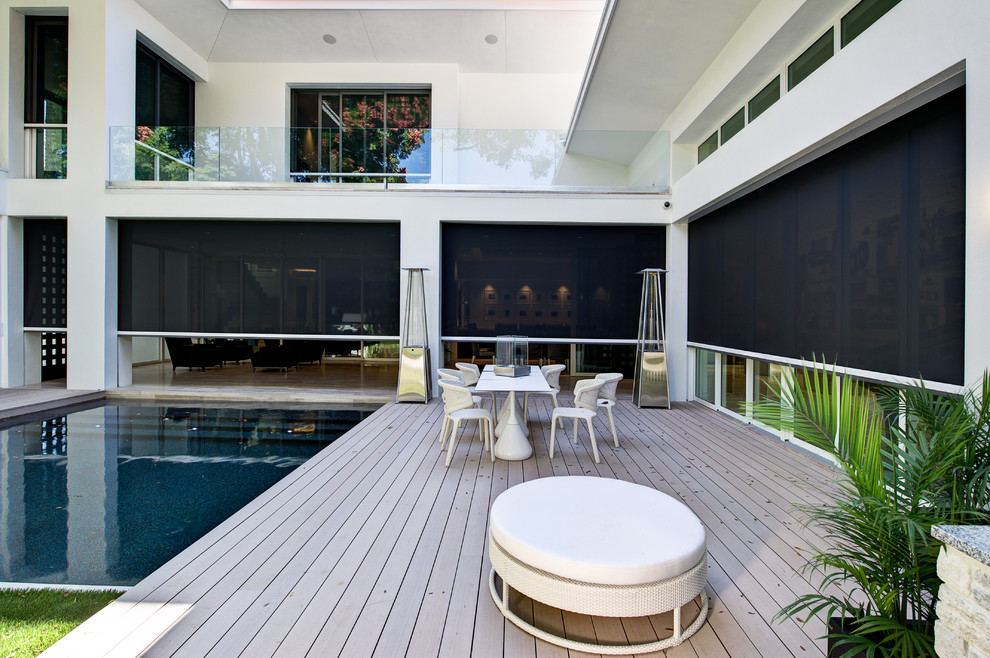 This is an example of a contemporary deck in Orlando with a roof extension.