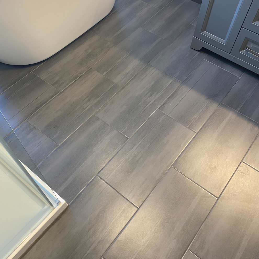 Example of a huge transitional master porcelain tile porcelain tile, gray floor and single-sink freestanding bathtub design with recessed-panel cabinets, a one-piece toilet, an undermount sink, quartzite countertops, white countertops and a built-in vanity