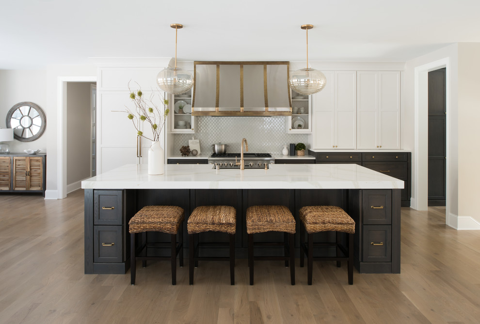 Inspiration for a large transitional galley eat-in kitchen in Minneapolis with a farmhouse sink, shaker cabinets, grey cabinets, quartz benchtops, white splashback, mosaic tile splashback, panelled appliances, light hardwood floors, with island and brown floor.