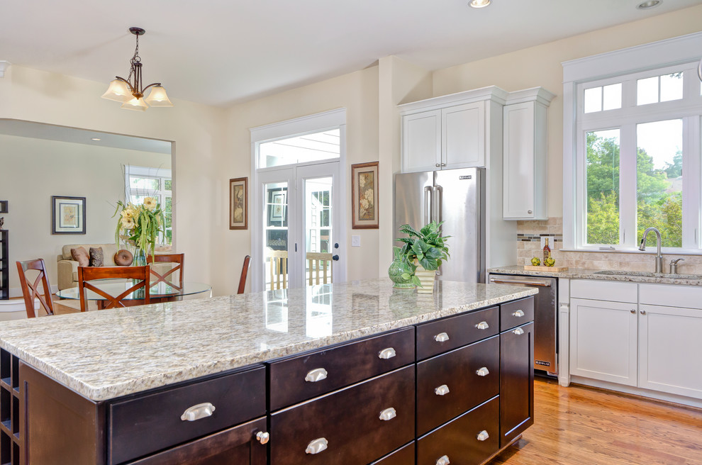 Inspiration for a l-shaped medium tone wood floor open concept kitchen remodel in DC Metro with an undermount sink, shaker cabinets, white cabinets, granite countertops, multicolored backsplash, stone tile backsplash, stainless steel appliances and an island