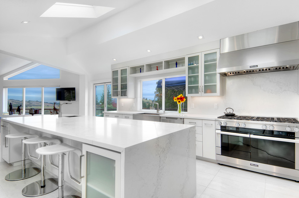 Inspiration for a large contemporary galley separate kitchen in San Diego with an undermount sink, glass-front cabinets, white cabinets, marble benchtops, white splashback, stone slab splashback, stainless steel appliances, marble floors and with island.