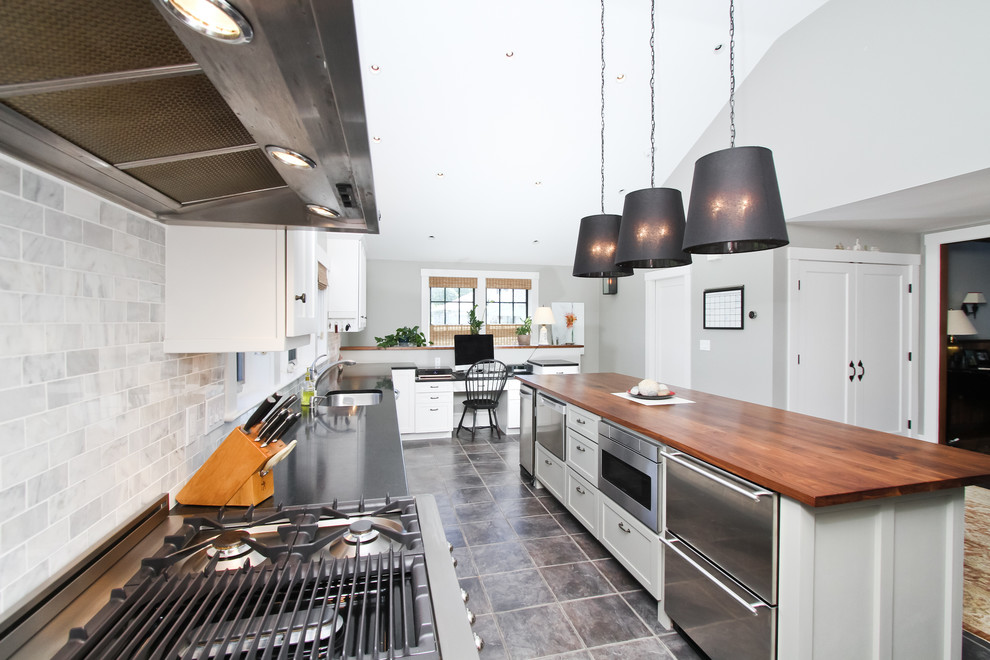 Inspiration for a large transitional u-shaped slate floor and gray floor eat-in kitchen remodel in Boston with an undermount sink, shaker cabinets, white cabinets, granite countertops, stone tile backsplash, stainless steel appliances, an island and multicolored backsplash