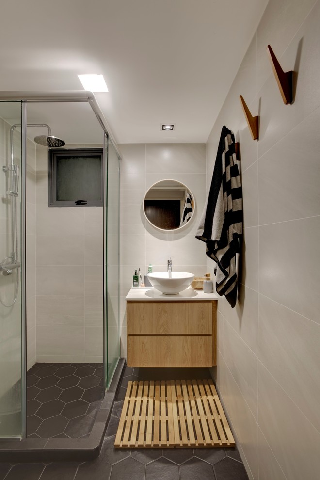 Inspiration for a contemporary 3/4 bathroom in Singapore with flat-panel cabinets, light wood cabinets, a corner shower, beige tile, a vessel sink, grey floor, a sliding shower screen and white benchtops.