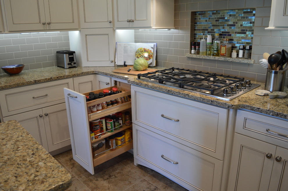 Open concept kitchen - mid-sized traditional u-shaped ceramic tile and brown floor open concept kitchen idea with an undermount sink, beaded inset cabinets, white cabinets, granite countertops, gray backsplash, subway tile backsplash, stainless steel appliances, an island and gray countertops