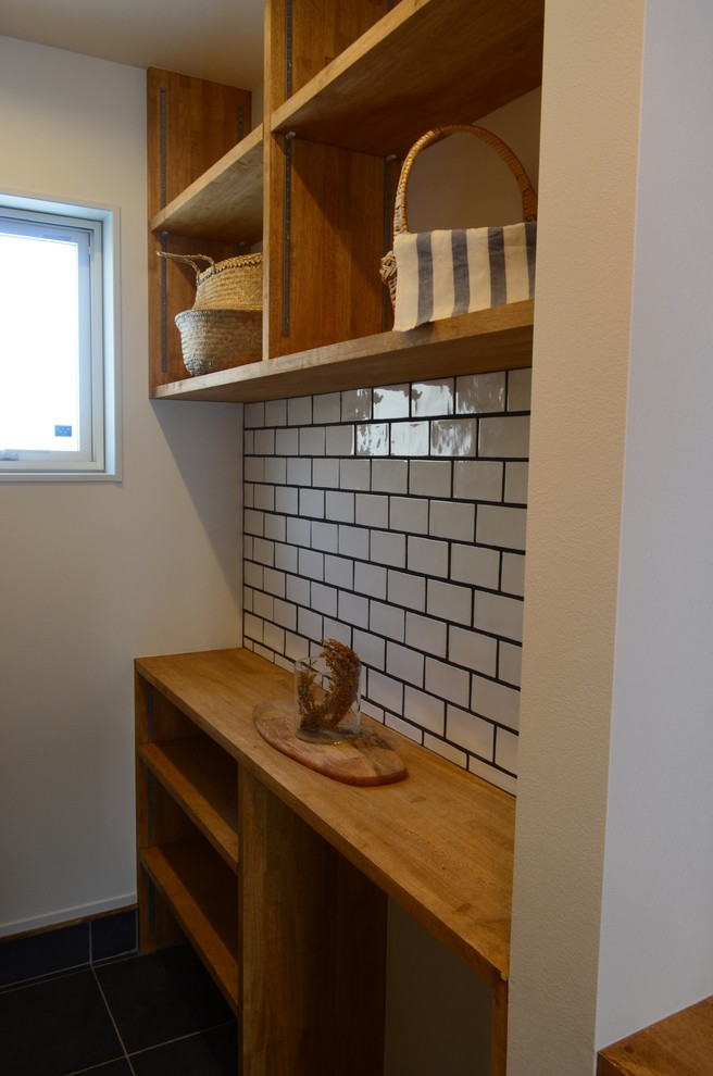 This is an example of a mid-sized industrial wine cellar in Other with ceramic floors, display racks and black floor.